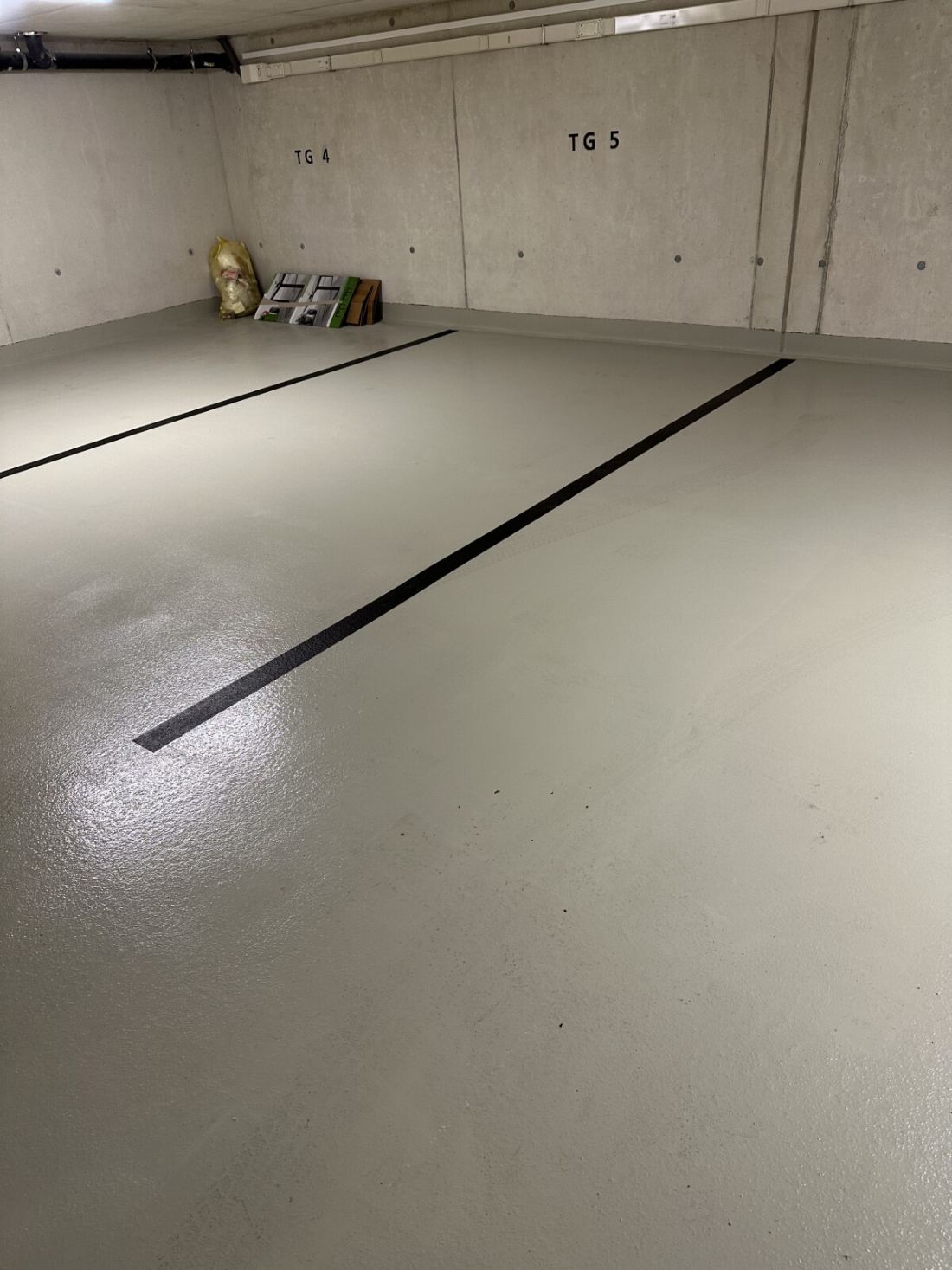 Frisch mit Kärcher-Hochdruck gereinigter Tiefgaragenboden mit Stellplatzmarkierungen