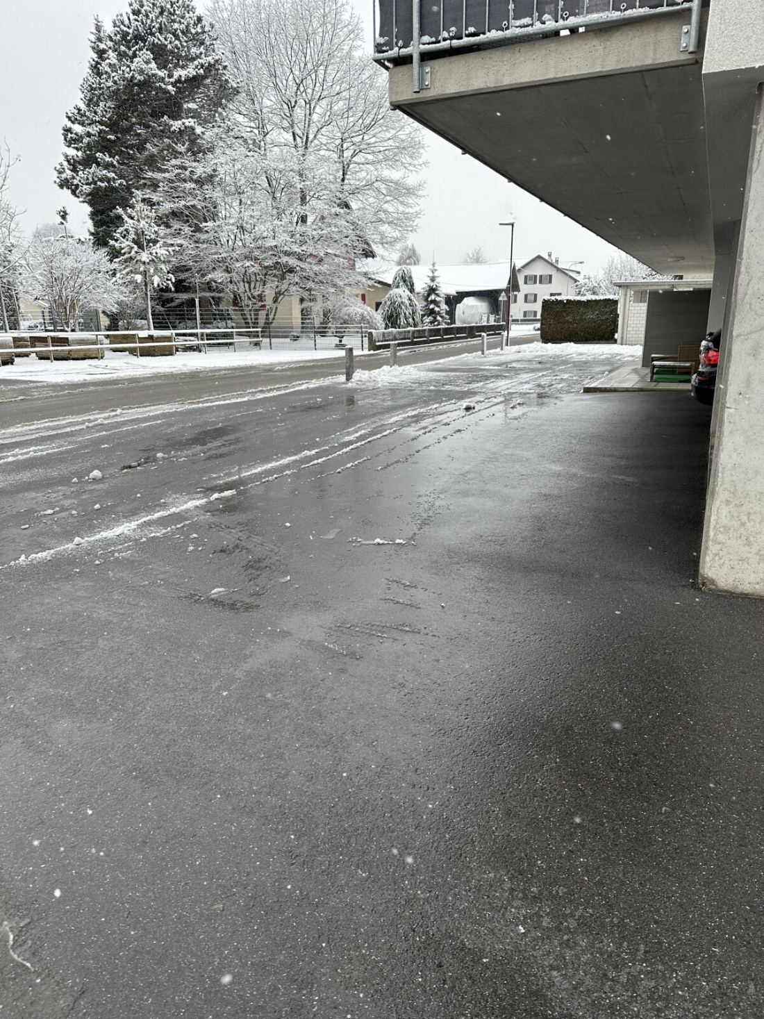 Von Schnee geräumte und gestreute Hofeinfahrt einer Wohnanlage im Winter